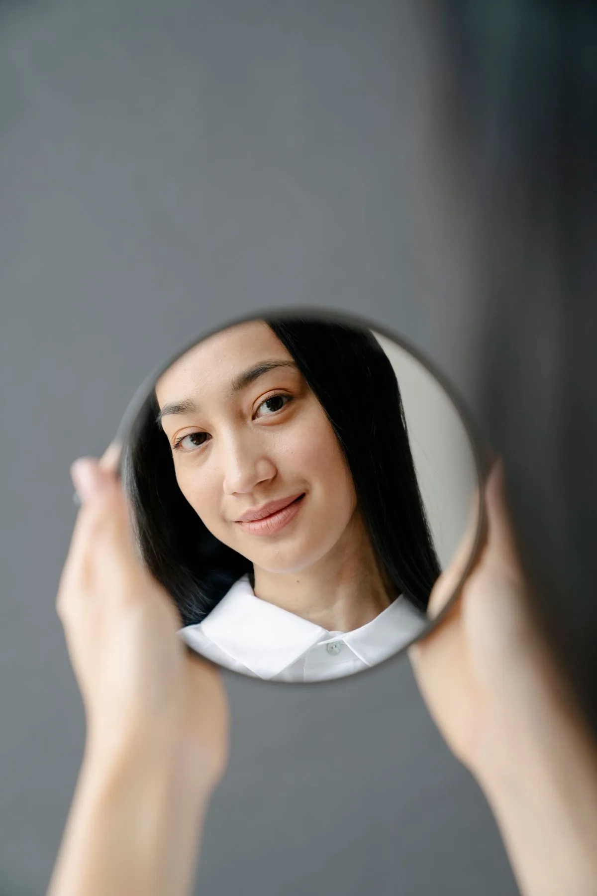 Cô gái soi gương tròn xem lại gương mặt