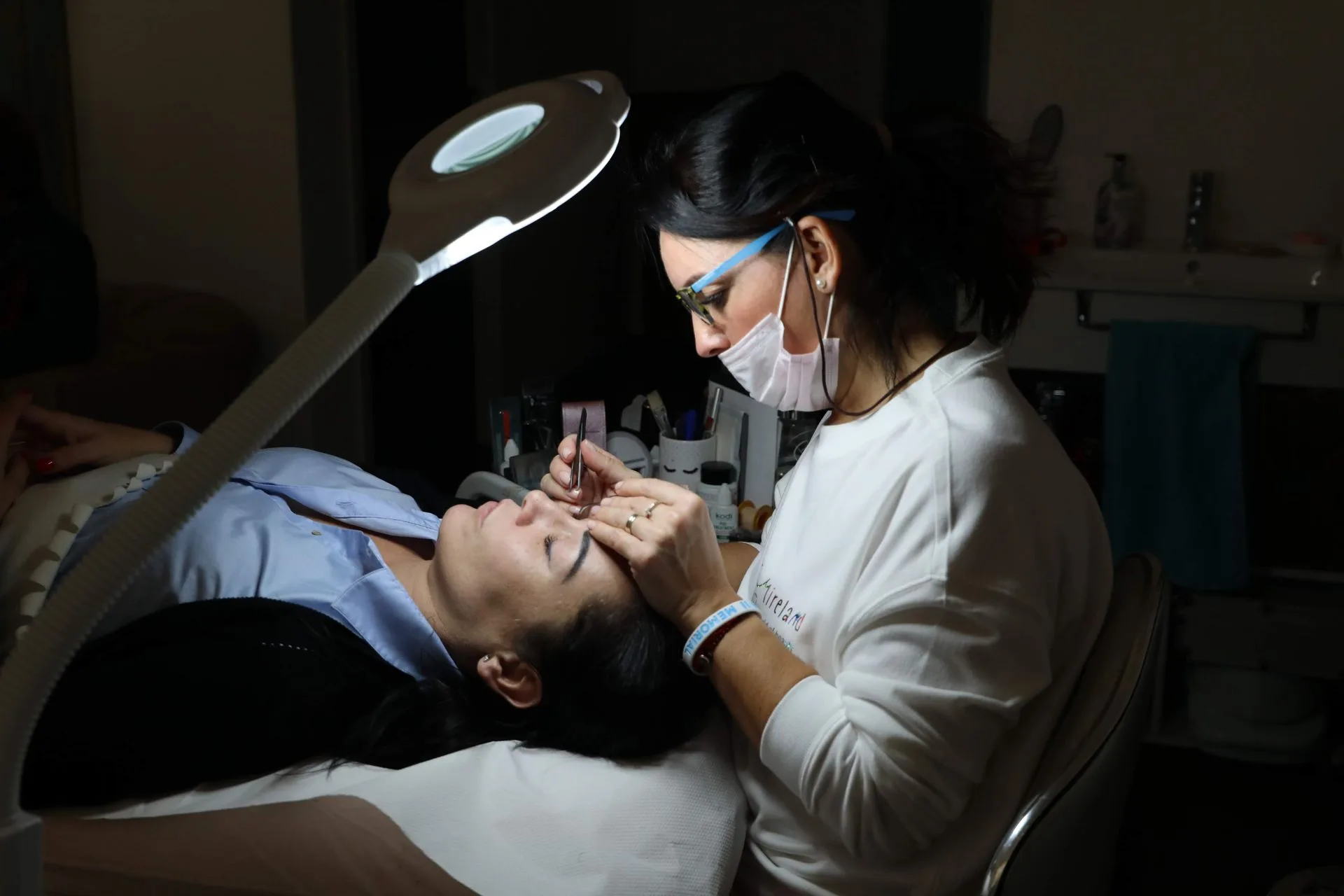 Kỹ thuật viên đeo khẩu trang làm việc dưới đèn soi