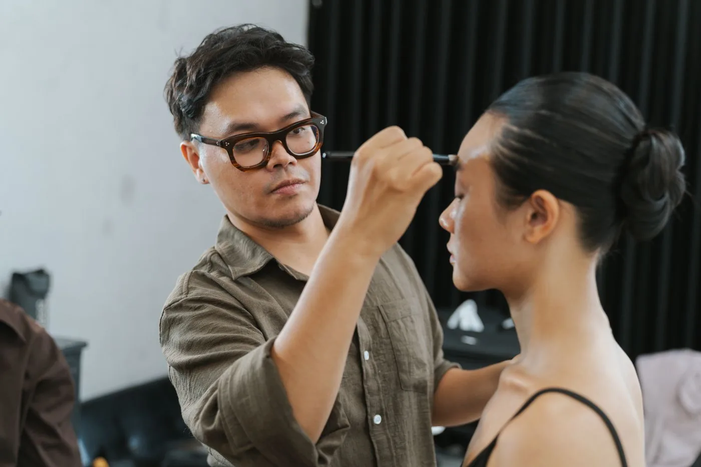 Thợ trang điểm kẻ chân mày cho người mẫu